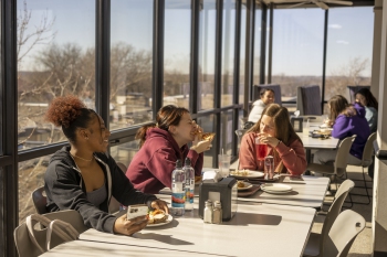 Students eating in Dining Hall near windows