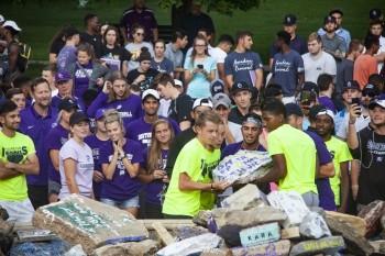 Students putting a rock on The Mound