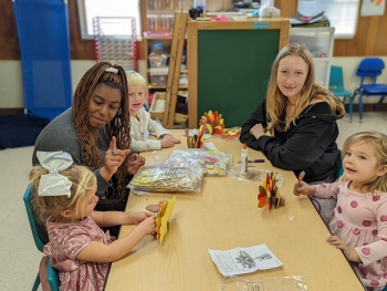 SC Learning Center students working with children at a table