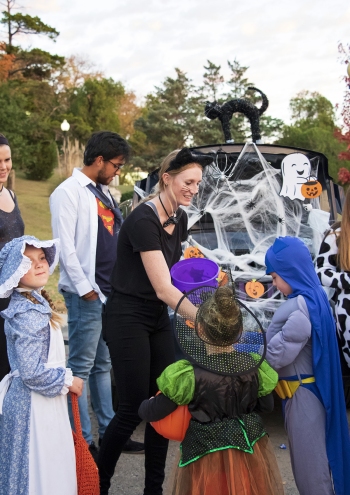 Students handing out candy at Trunk-or-Treat event